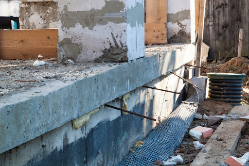 Foundation underpinning methods being employed to secure a house’s foundation.